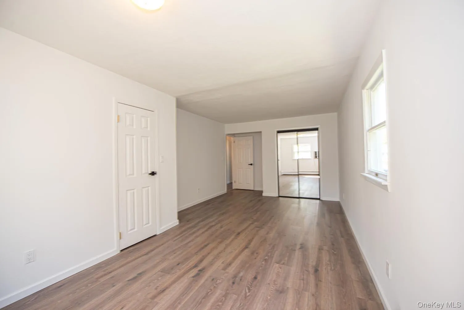 Unfurnished room with wood finished floors and baseboards Unfurnished room with wood finished floors and baseboards