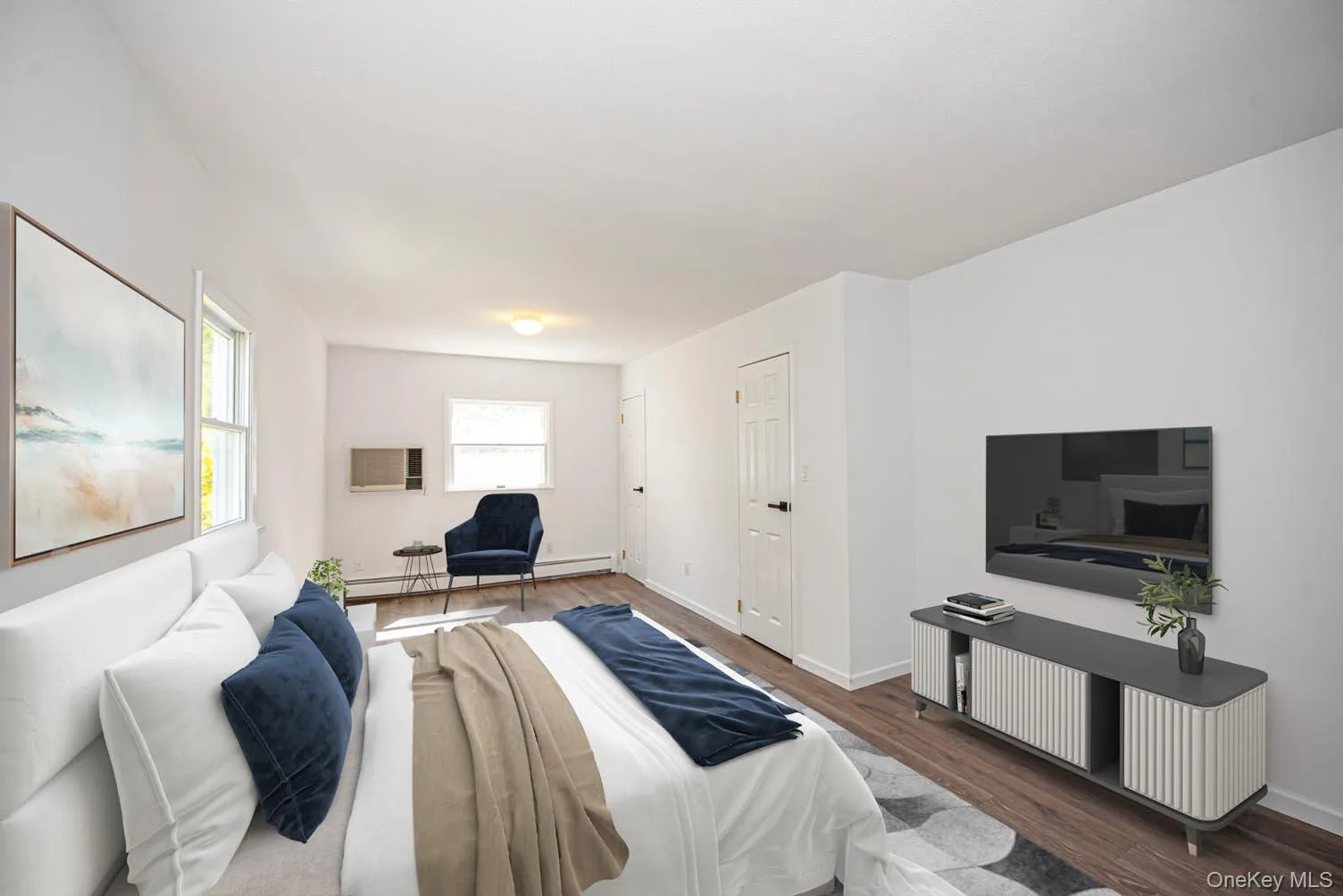 Bedroom featuring wood finished floors and a baseboard heating unit Bedroom featuring wood finished floors and a baseboard heating unit