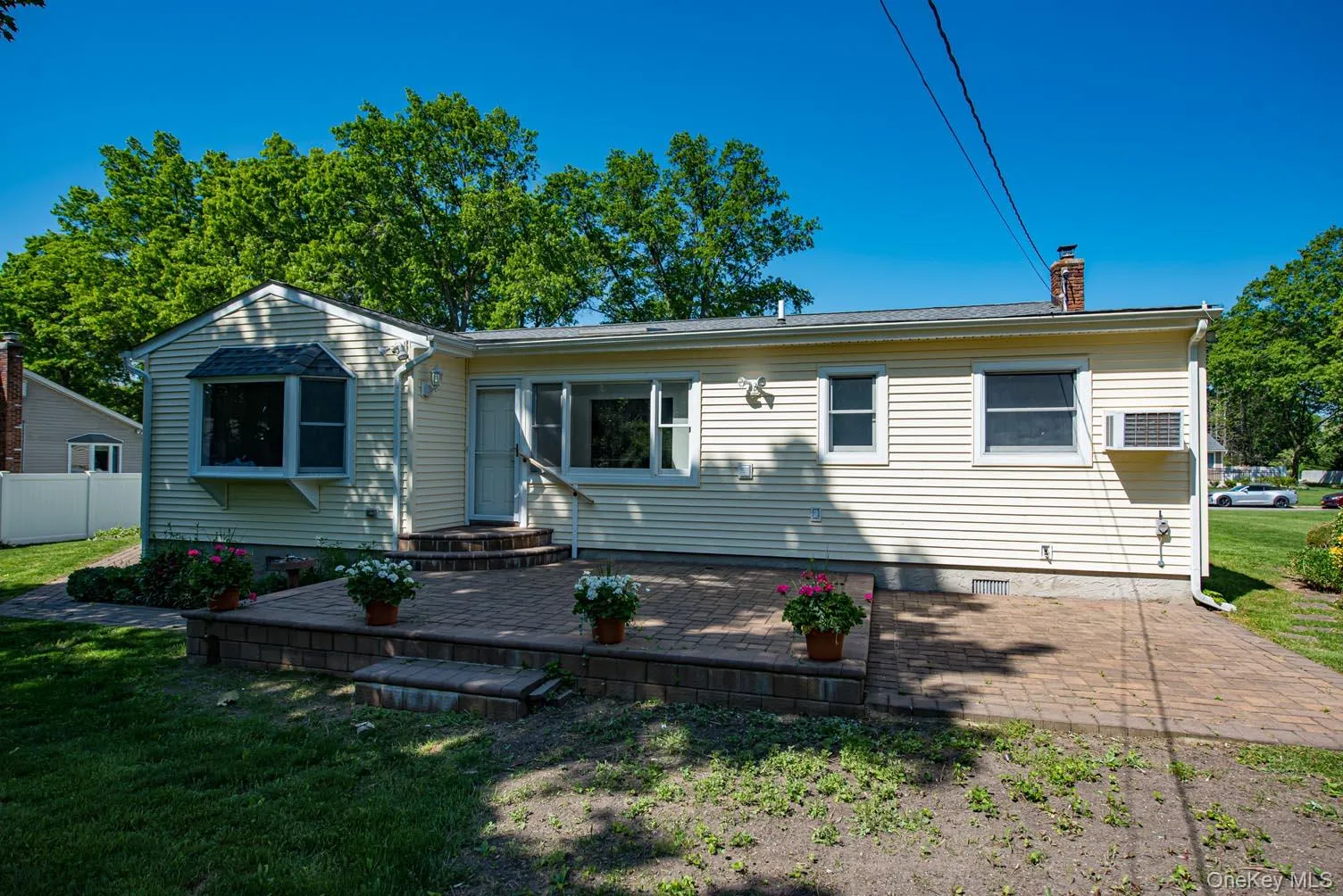 View of front of house featuring a chimney, crawl space, a patio area, and a wall unit AC View of front of house featuring a chimney, crawl space, a patio area, and a wall unit AC