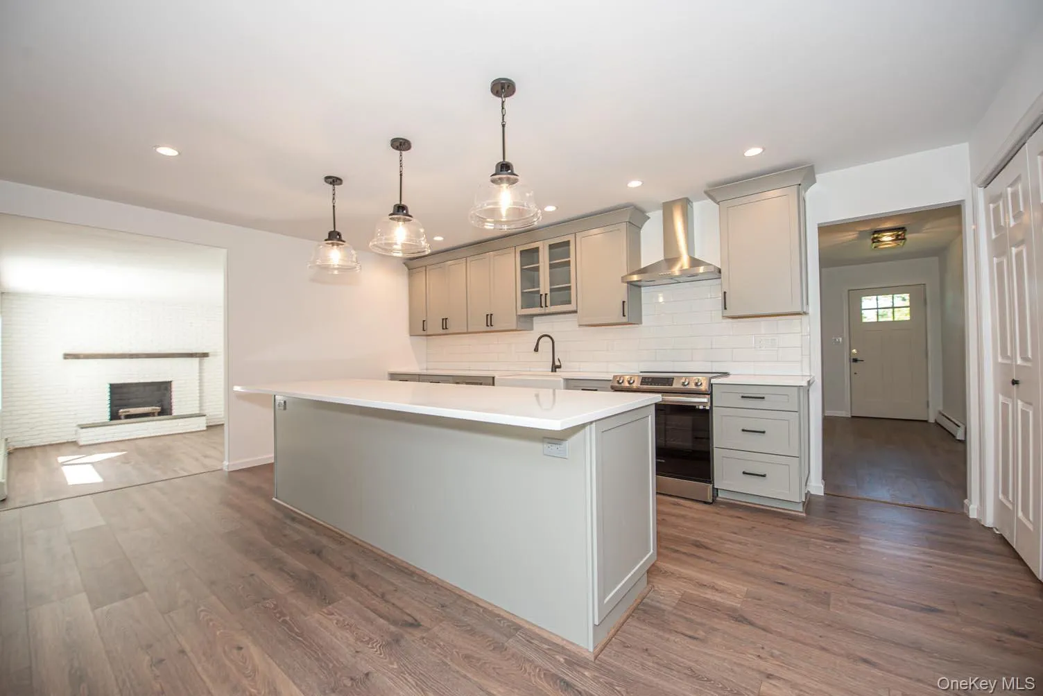 Kitchen featuring glass insert cabinets, gray cabinetry, a kitchen island, electric stove, and decorative light fixtures Kitchen featuring glass insert cabinets, gray cabinetry, a kitchen island, electric stove, and decorative light fixtures