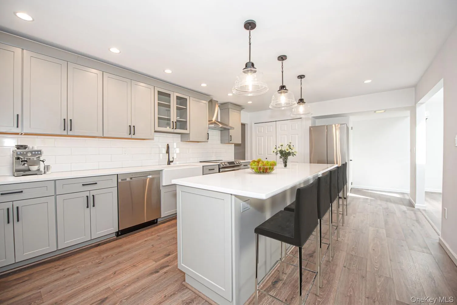 Kitchen featuring gray cabinetry, pendant lighting, glass insert cabinets, appliances with stainless steel finishes, and recessed lighting Kitchen featuring gray cabinetry, pendant lighting, glass insert cabinets, appliances with stainless steel finishes, and recessed lighting