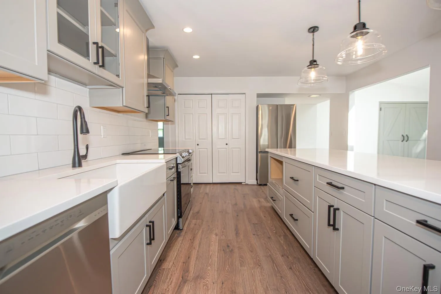 Kitchen featuring gray cabinetry, appliances with stainless steel finishes, tasteful backsplash, dark wood-style flooring, and recessed lighting Kitchen featuring gray cabinetry, appliances with stainless steel finishes, tasteful backsplash, dark wood-style flooring, and recessed lighting