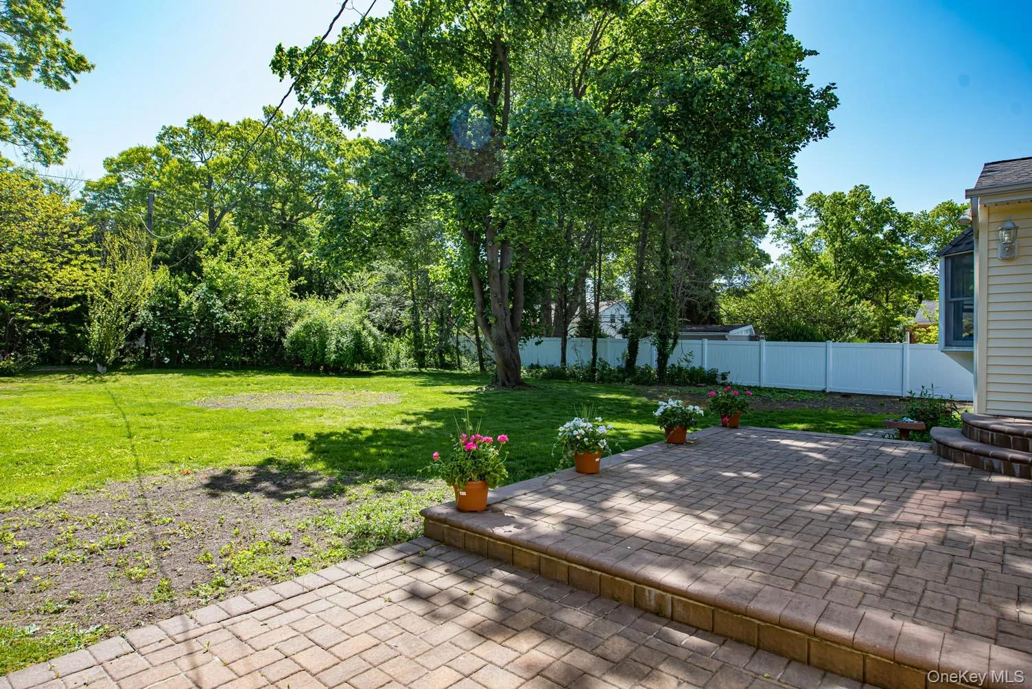 Fenced backyard with a patio area Fenced backyard with a patio area