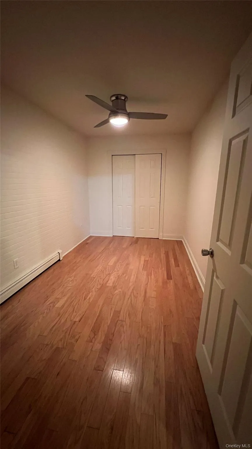 Unfurnished bedroom featuring hardwood / wood-style floors, baseboard heating, a closet, and a ceiling fan Unfurnished bedroom featuring hardwood / wood-style floors, baseboard heating, a closet, and a ceiling fan