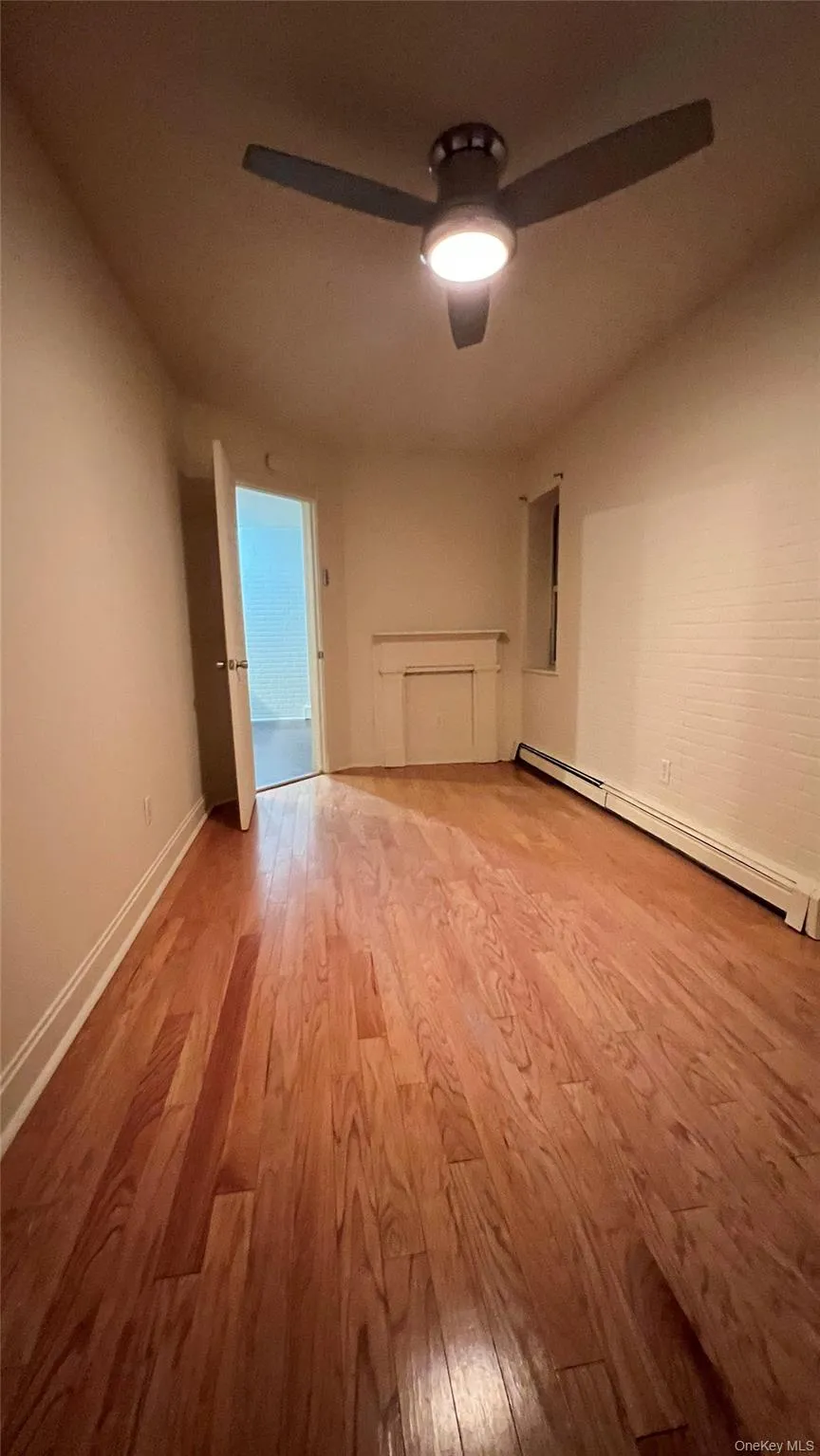 Empty room featuring a baseboard heating unit and light wood-style flooring Empty room featuring a baseboard heating unit and light wood-style flooring