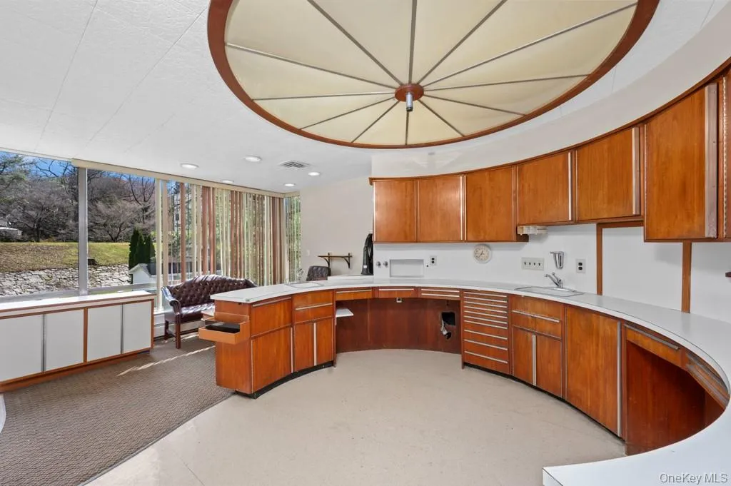 Kitchen with brown cabinetry, light countertops, and a peninsula Kitchen with brown cabinetry, light countertops, and a peninsula