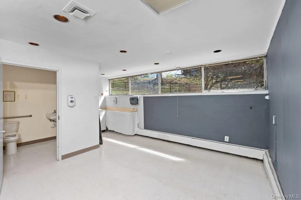 Empty room featuring a baseboard radiator and light floors Empty room featuring a baseboard radiator and light floors