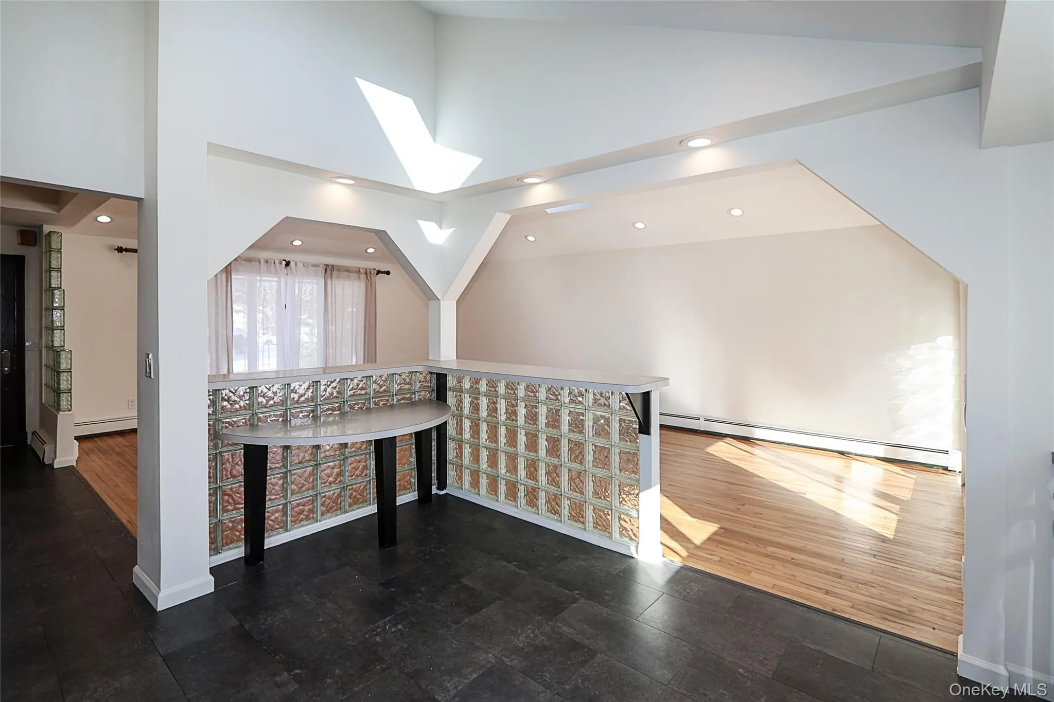 Bonus room featuring high vaulted ceiling, baseboard heating, a skylight, dark wood-style floors, and recessed lighting Bonus room featuring high vaulted ceiling, baseboard heating, a skylight, dark wood-style floors, and recessed lighting