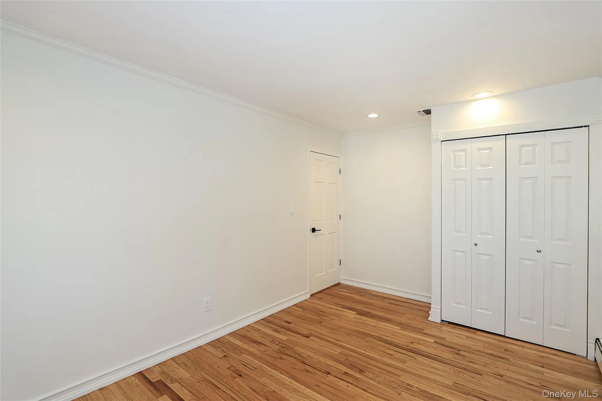 Unfurnished bedroom featuring crown molding, light wood-style floors, a closet, and recessed lighting Unfurnished bedroom featuring crown molding, light wood-style floors, a closet, and recessed lighting