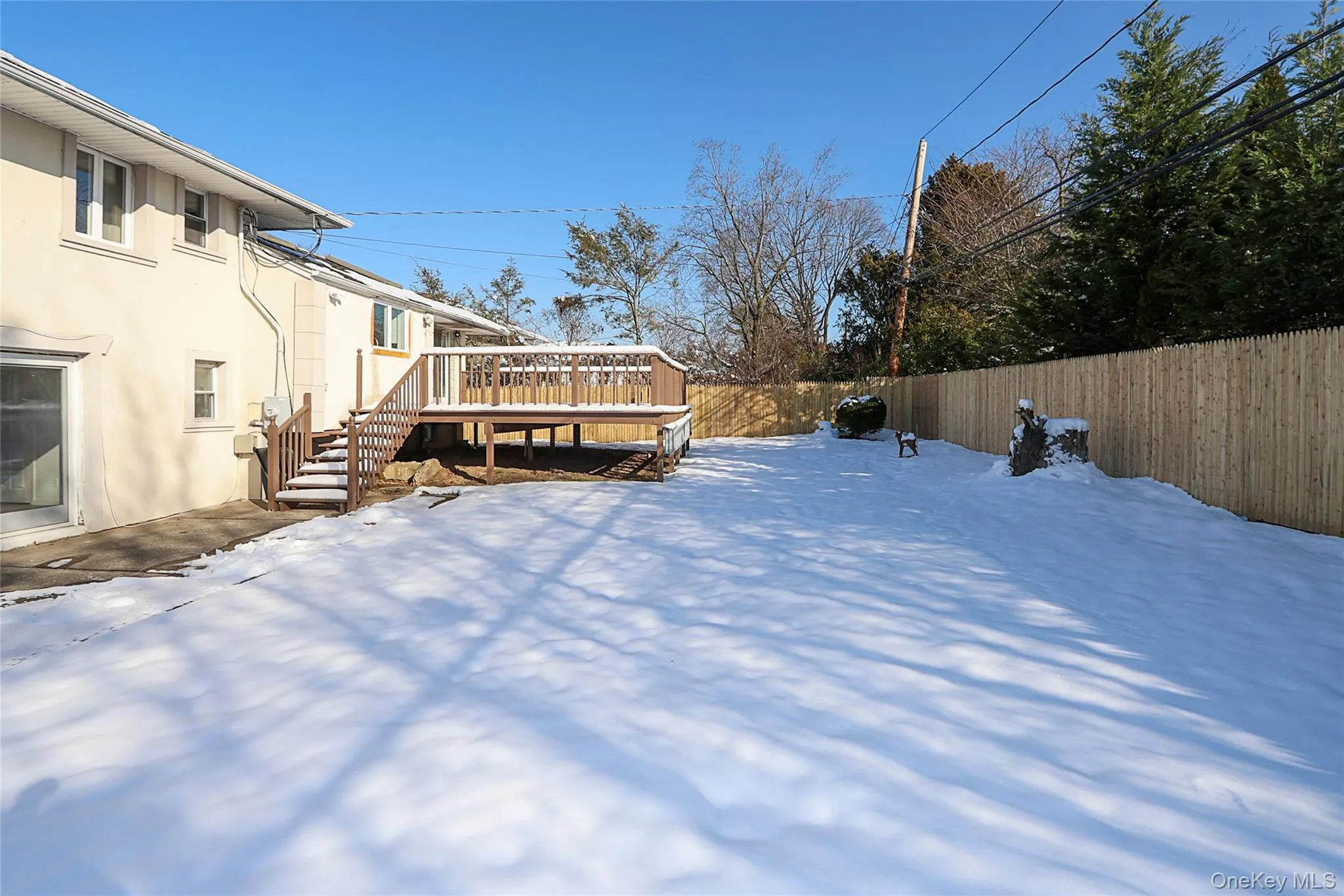 Yard with a fenced backyard, a wooden deck, and stairway Yard with a fenced backyard, a wooden deck, and stairway