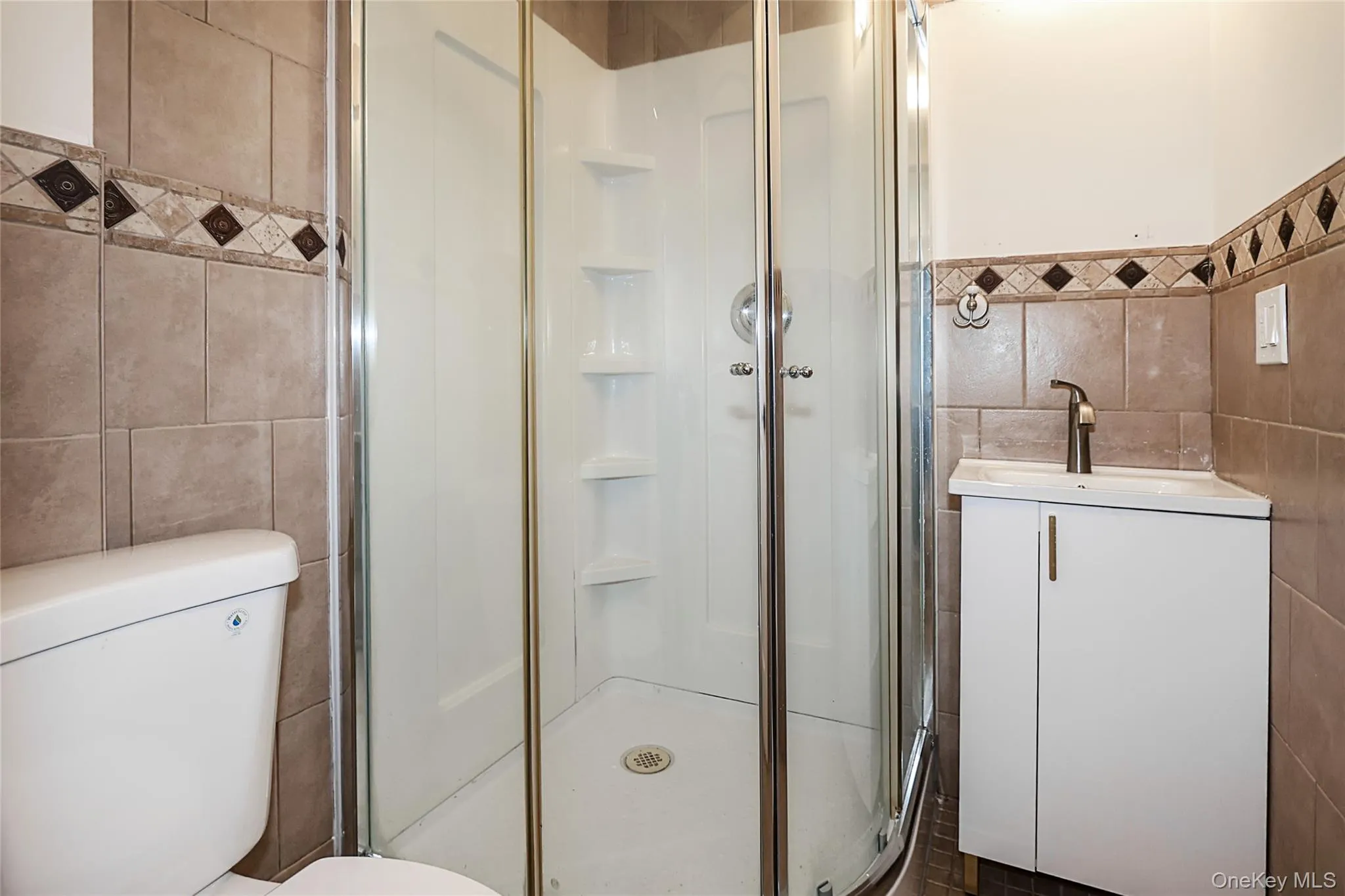 Bathroom featuring tile walls, vanity, and a stall shower Bathroom featuring tile walls, vanity, and a stall shower