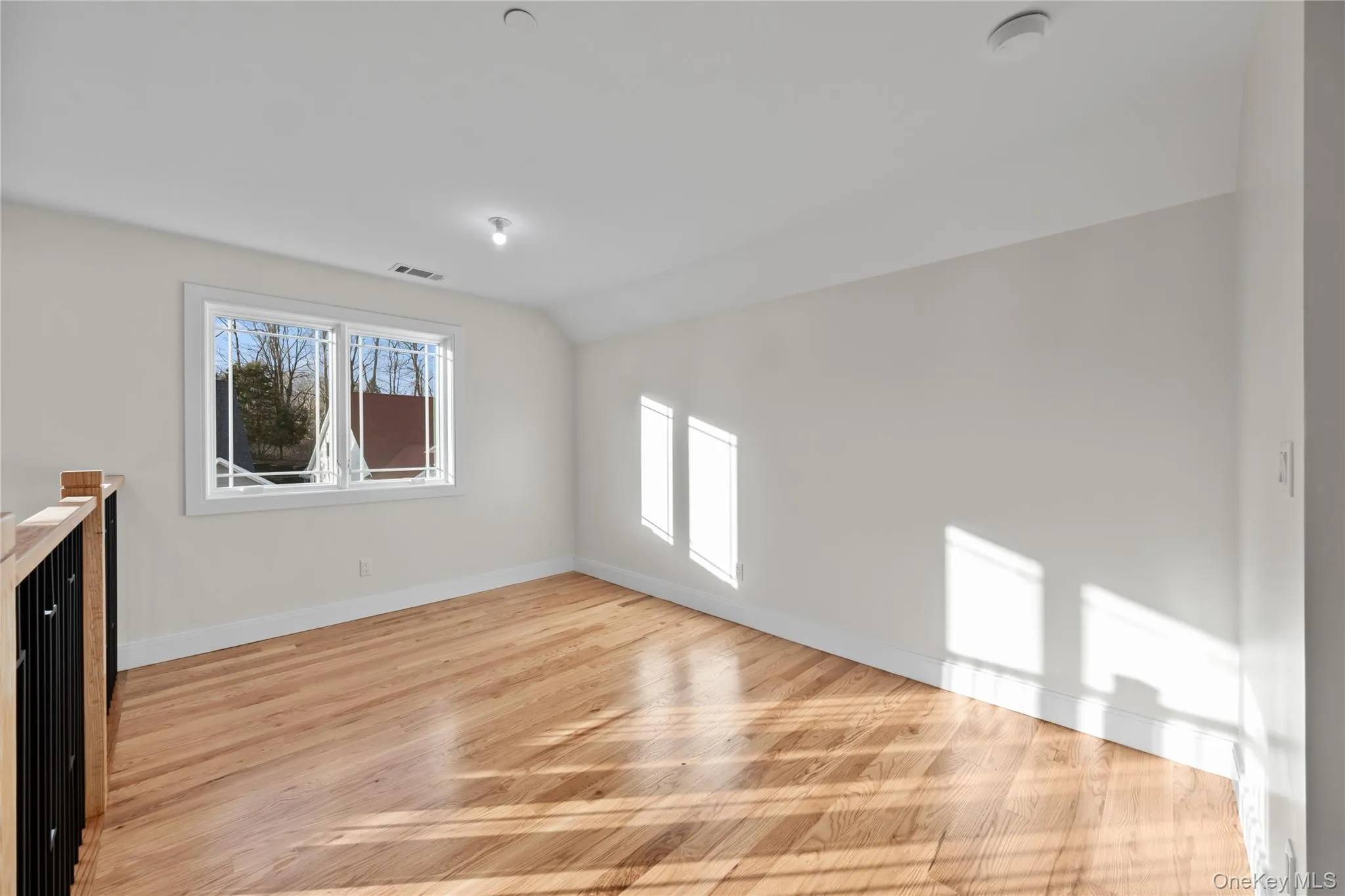 Empty room with vaulted ceiling and light wood-type flooring Empty room with vaulted ceiling and light wood-type flooring