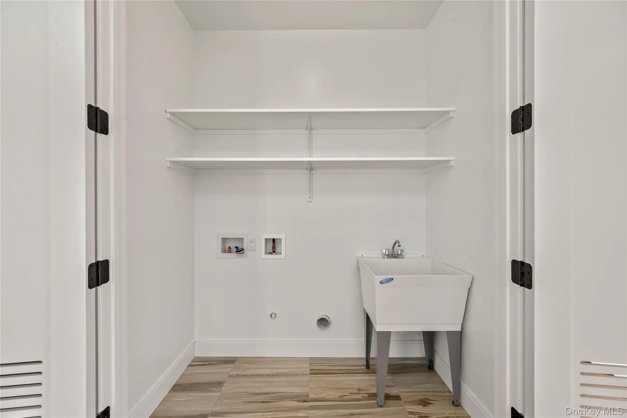 Washroom featuring washer hookup, light wood-style floors, and hookup for a gas dryer Washroom featuring washer hookup, light wood-style floors, and hookup for a gas dryer