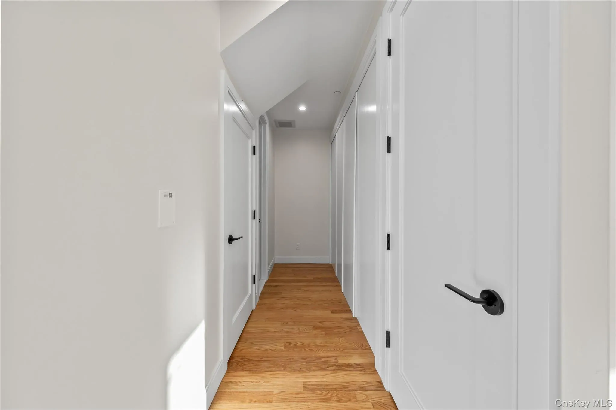 Hall with light wood-style floors and recessed lighting Hall with light wood-style floors and recessed lighting