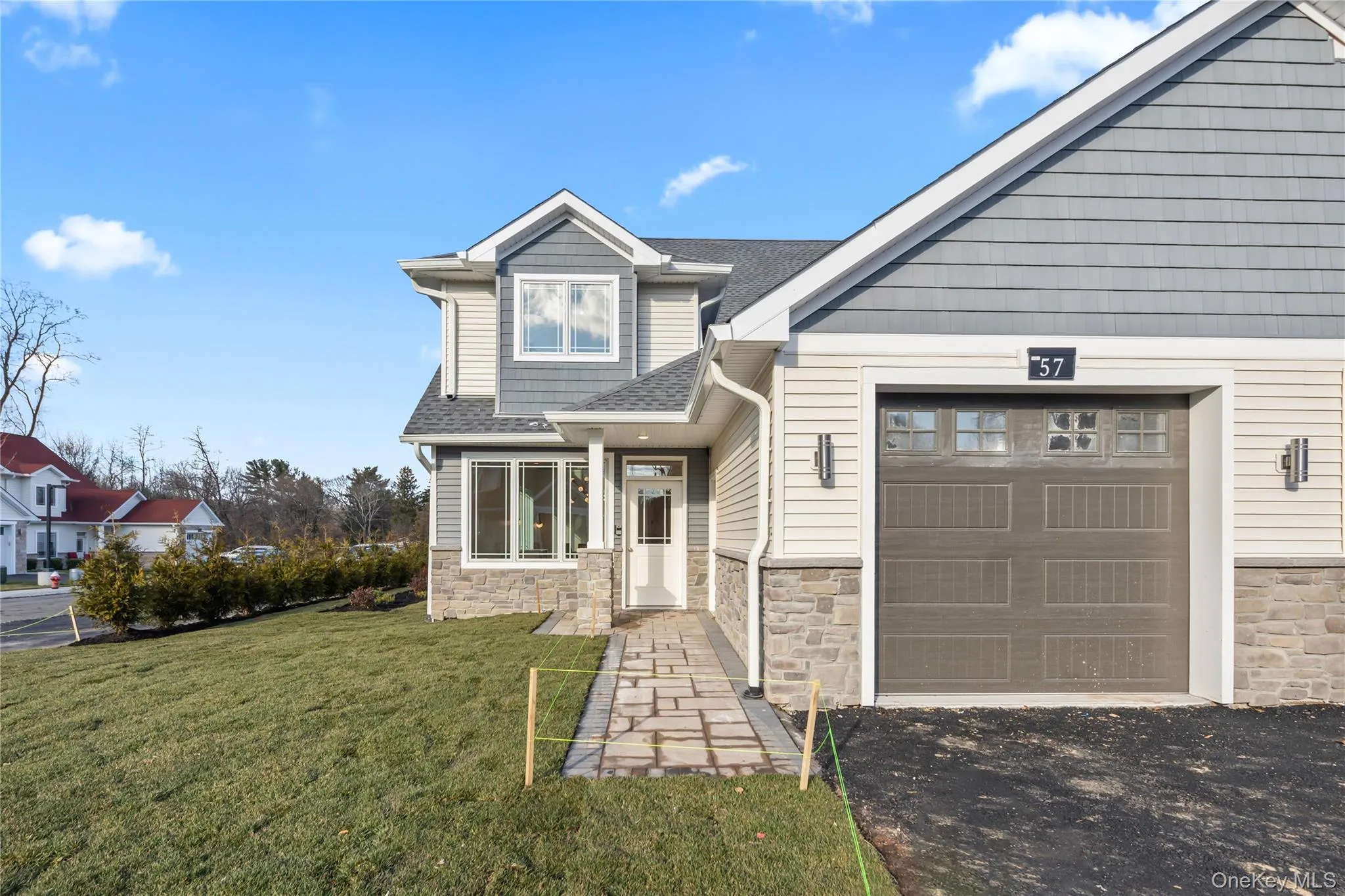 Craftsman house with stone siding, a front yard, and roof with shingles Craftsman house with stone siding, a front yard, and roof with shingles