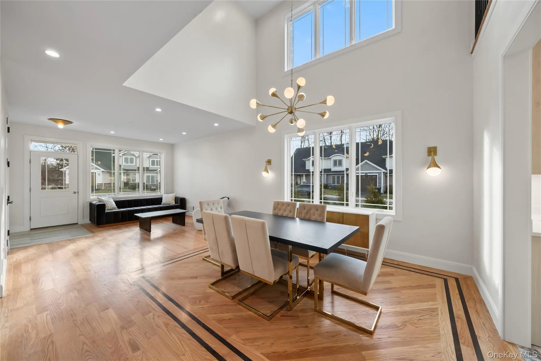 Dining area featuring a chandelier, light wood finished floors, a towering ceiling, and recessed lighting Dining area featuring a chandelier, light wood finished floors, a towering ceiling, and recessed lighting