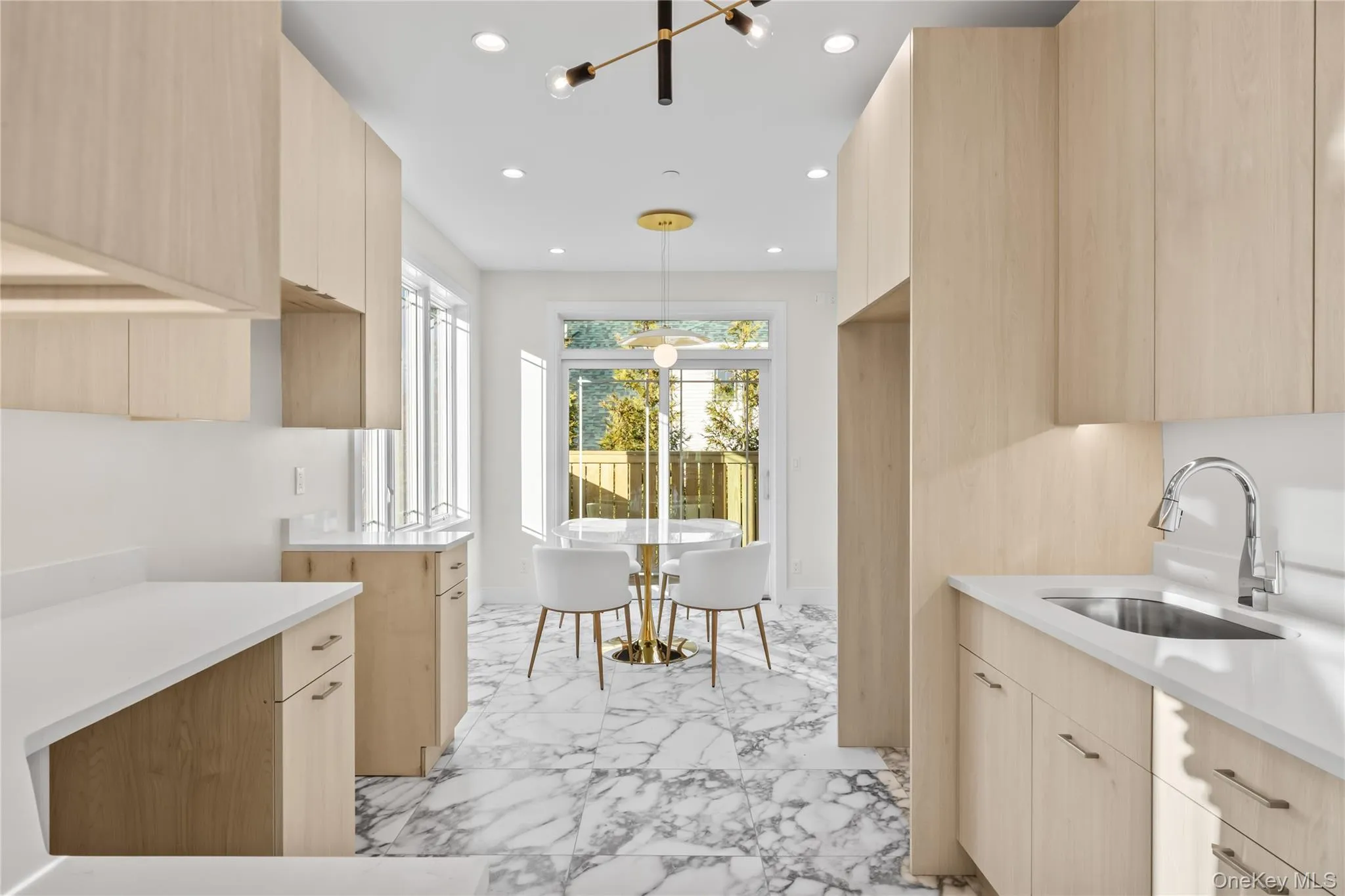 Kitchen featuring light brown cabinetry, modern cabinets, recessed lighting, pendant lighting, and light stone countertops Kitchen featuring light brown cabinetry, modern cabinets, recessed lighting, pendant lighting, and light stone countertops