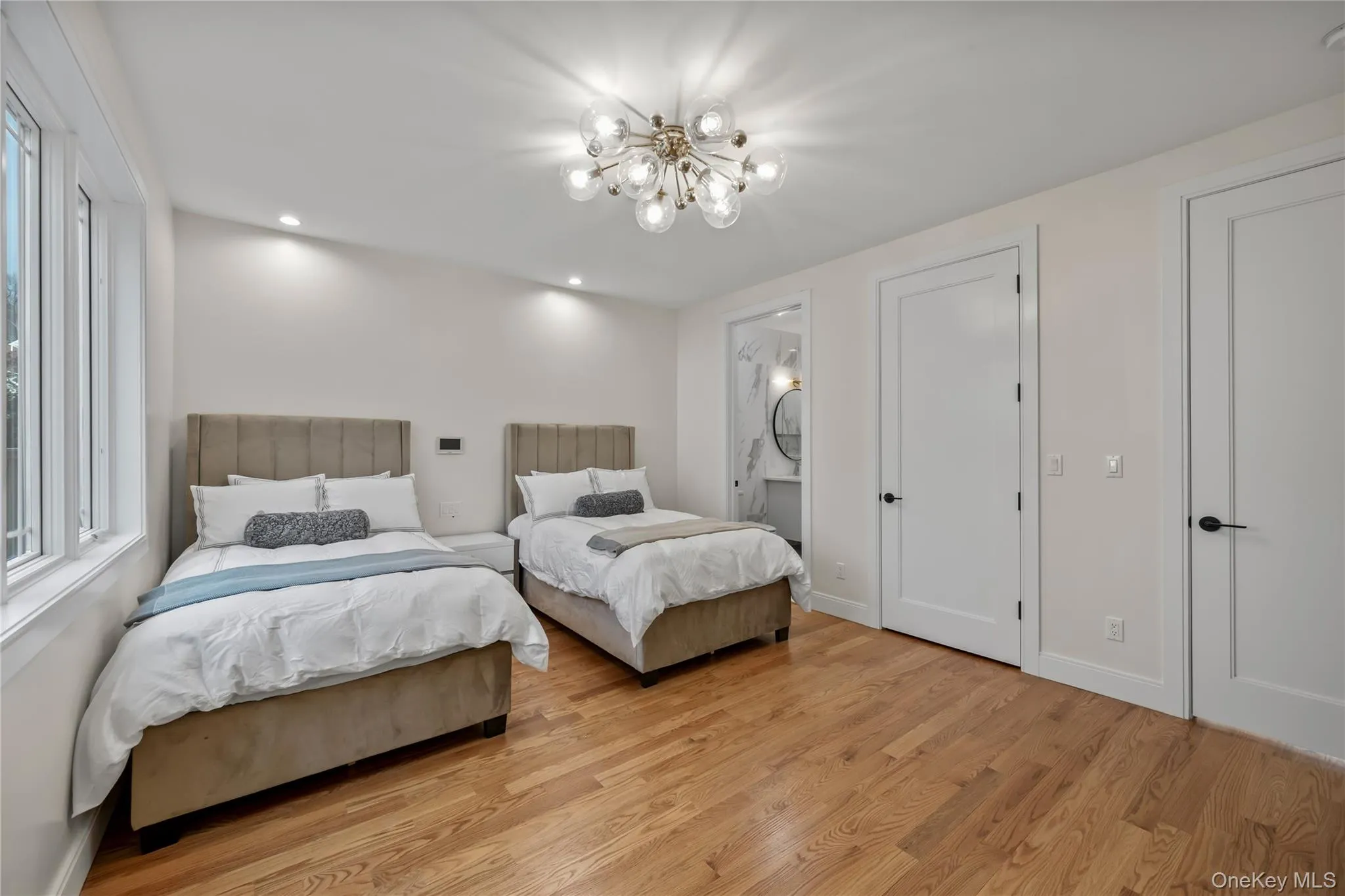 Bedroom with light wood-style flooring, recessed lighting, ensuite bathroom, and a chandelier Bedroom with light wood-style flooring, recessed lighting, ensuite bathroom, and a chandelier