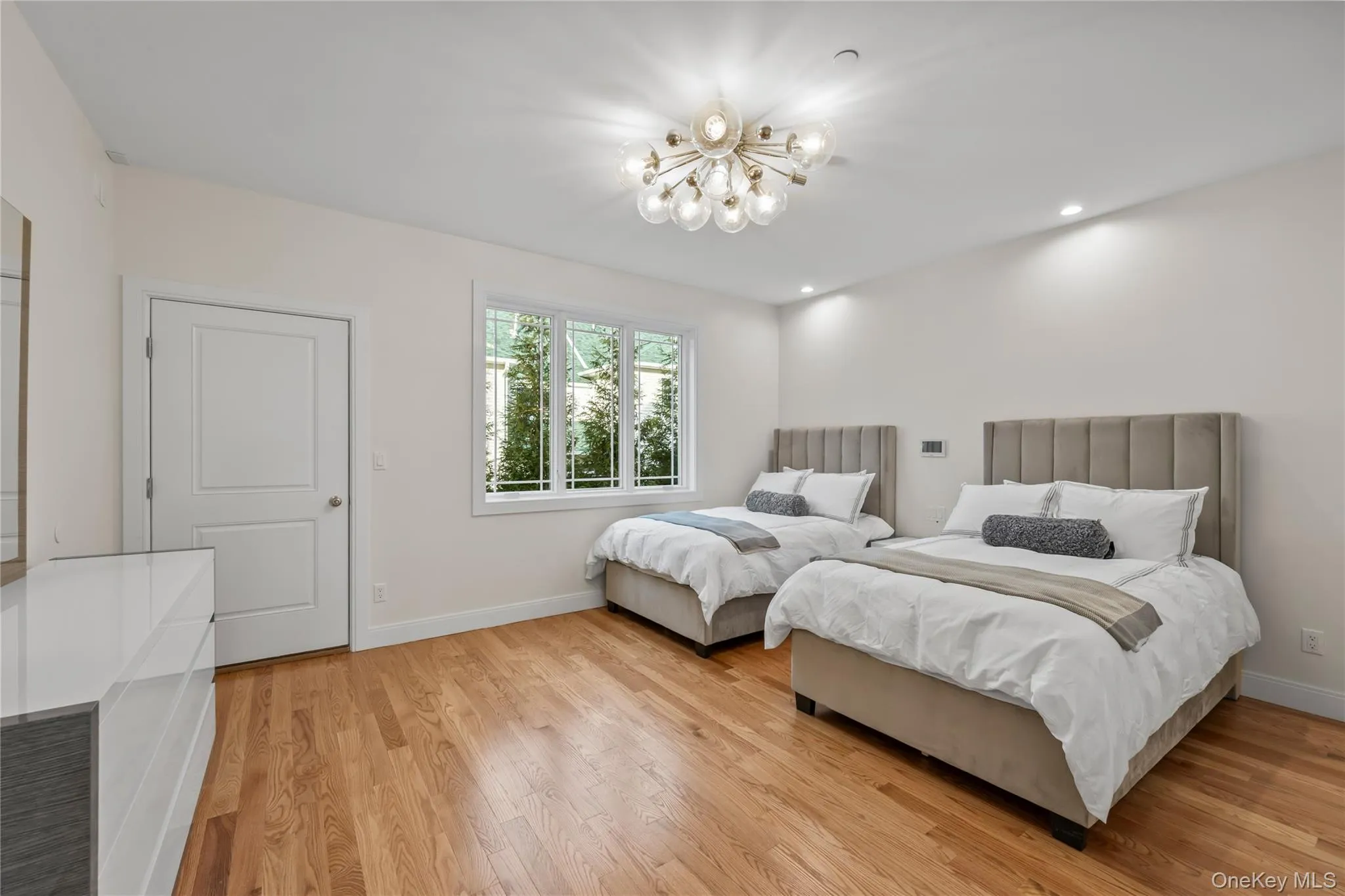 Bedroom with light wood finished floors, a chandelier, and recessed lighting Bedroom with light wood finished floors, a chandelier, and recessed lighting