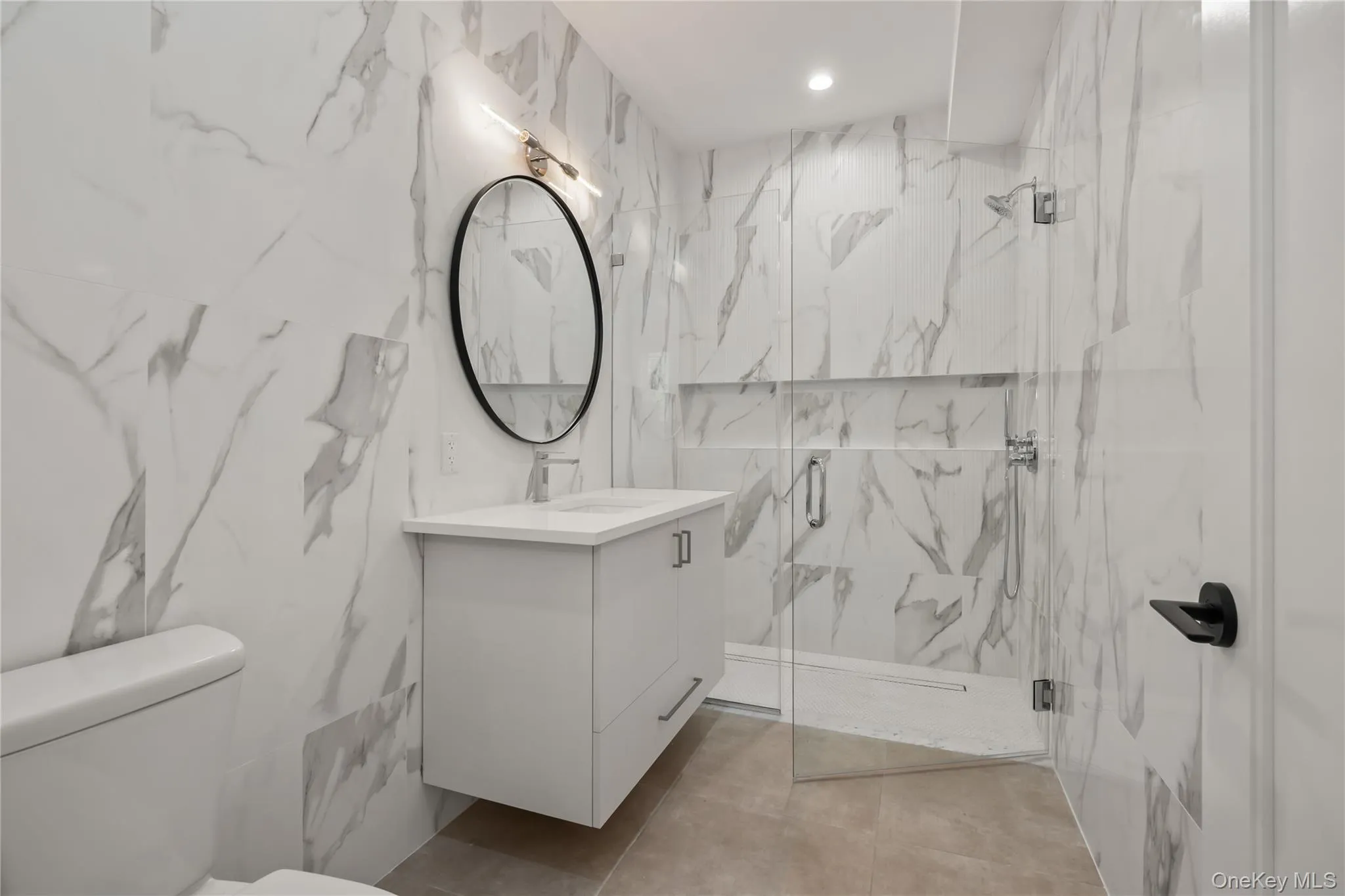 Bathroom with a marble finish shower and vanity Bathroom with a marble finish shower and vanity