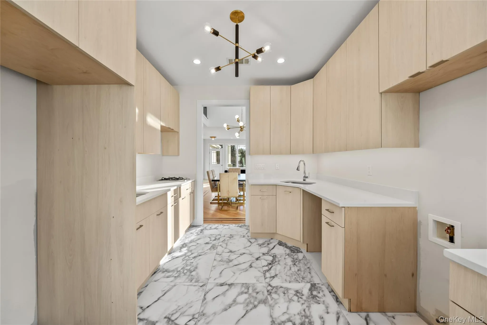 Kitchen featuring light brown cabinetry, modern cabinets, light marble finish flooring, a chandelier, and recessed lighting Kitchen featuring light brown cabinetry, modern cabinets, light marble finish flooring, a chandelier, and recessed lighting