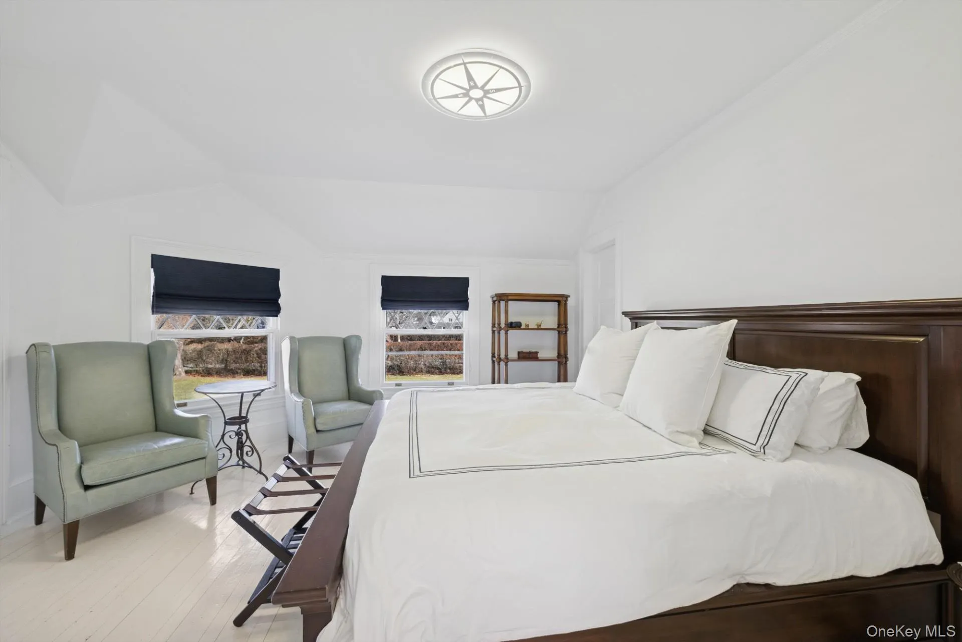 Bedroom featuring light wood-style flooring and vaulted ceiling Bedroom featuring light wood-style flooring and vaulted ceiling