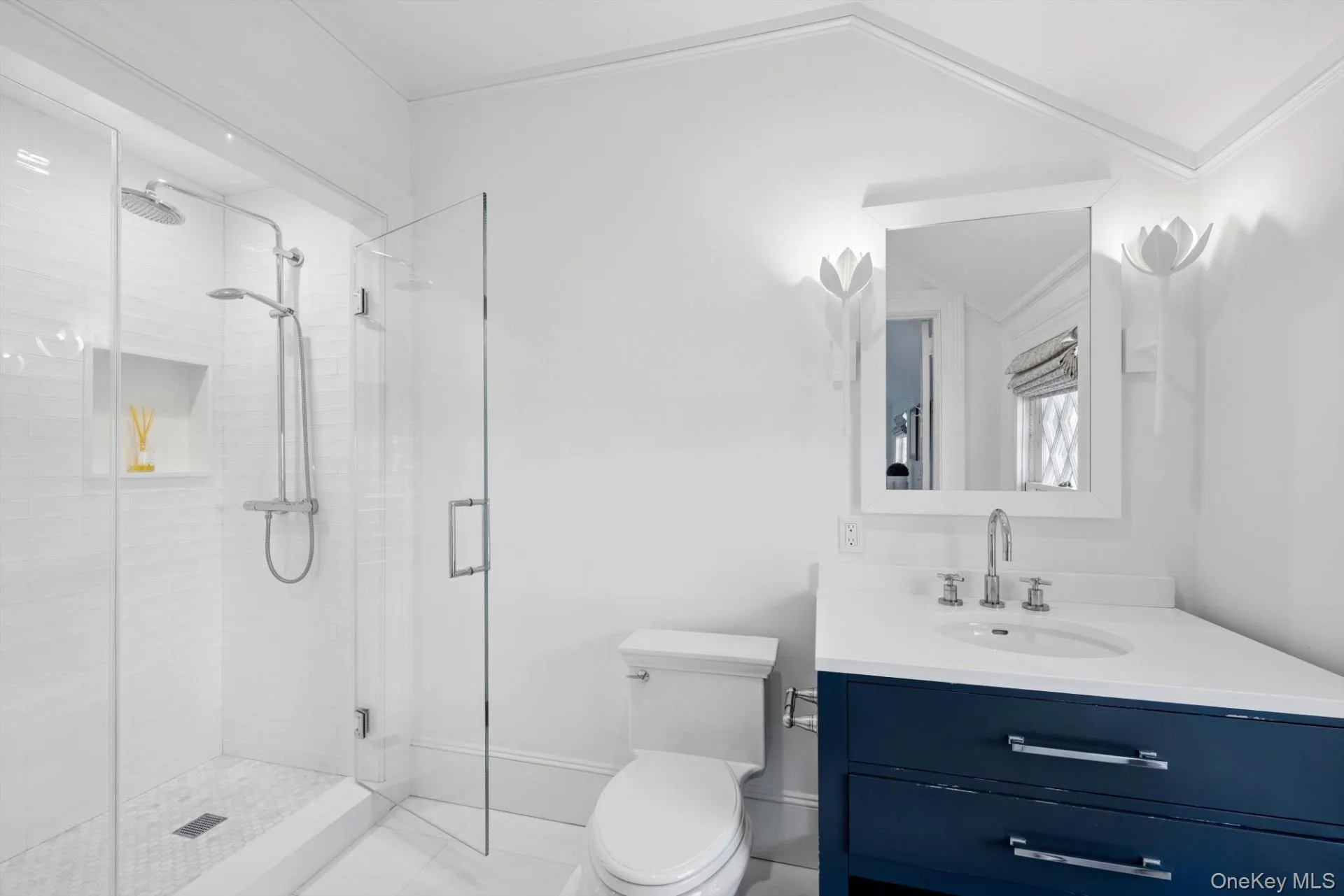 Full bathroom with a shower stall, vanity, and ornamental molding Full bathroom with a shower stall, vanity, and ornamental molding