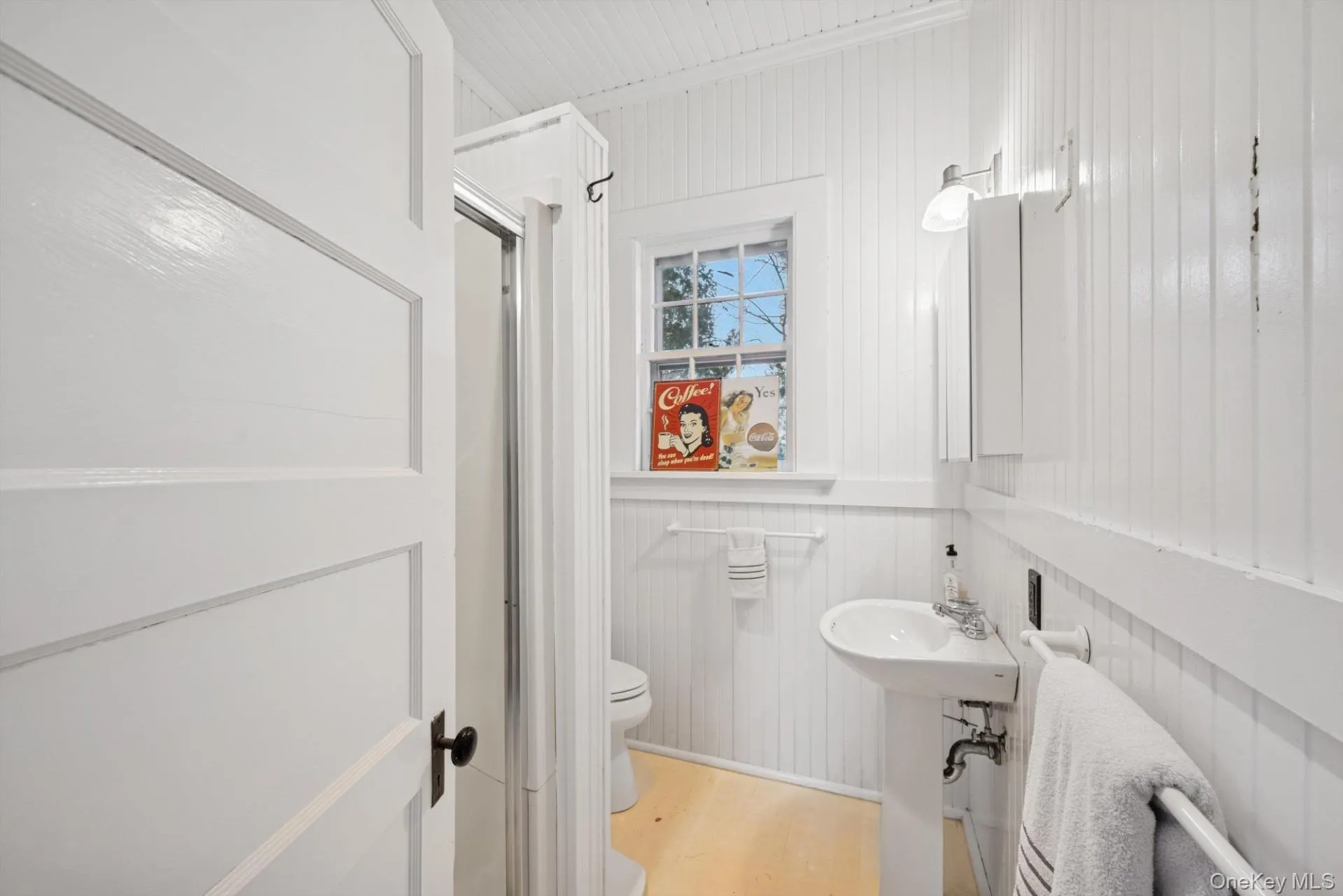 Bathroom with a shower stall, light wood-type flooring, wood walls, and crown molding Bathroom with a shower stall, light wood-type flooring, wood walls, and crown molding