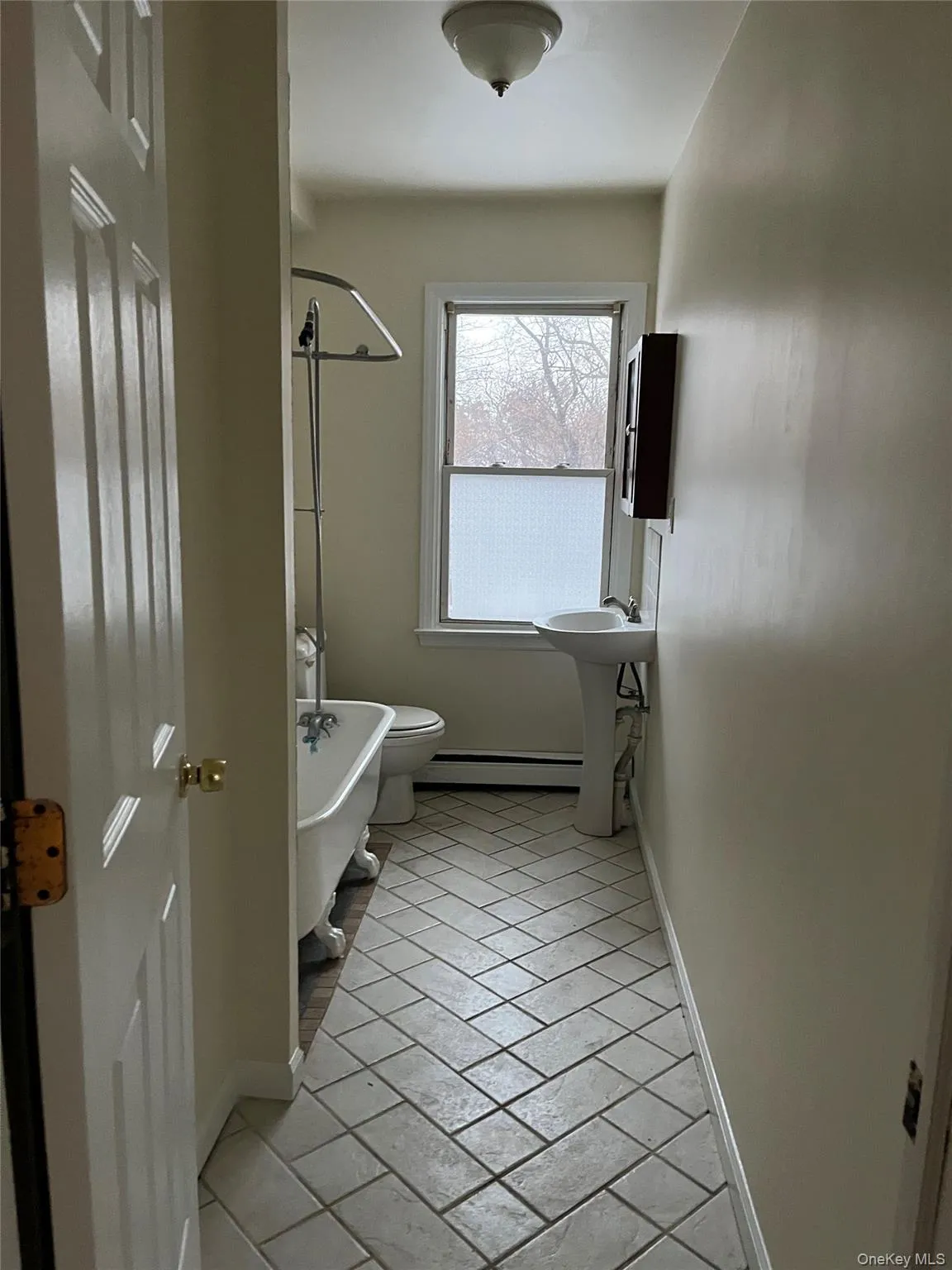 Full bath with baseboards and a baseboard radiator Full bath with baseboards and a baseboard radiator