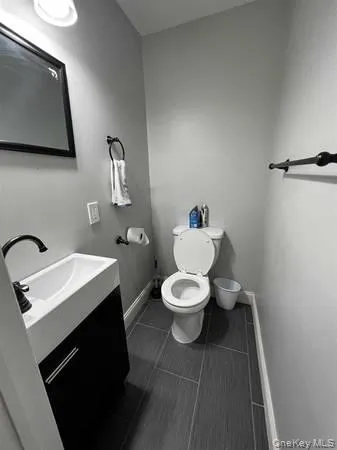 Half bath featuring vanity and dark tile patterned floors Half bath featuring vanity and dark tile patterned floors