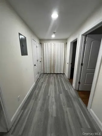Hallway featuring dark wood-style flooring and electric panel Hallway featuring dark wood-style flooring and electric panel