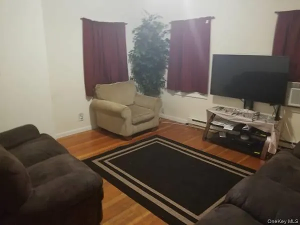 Living area with light wood finished floors and a baseboard radiator Living area with light wood finished floors and a baseboard radiator