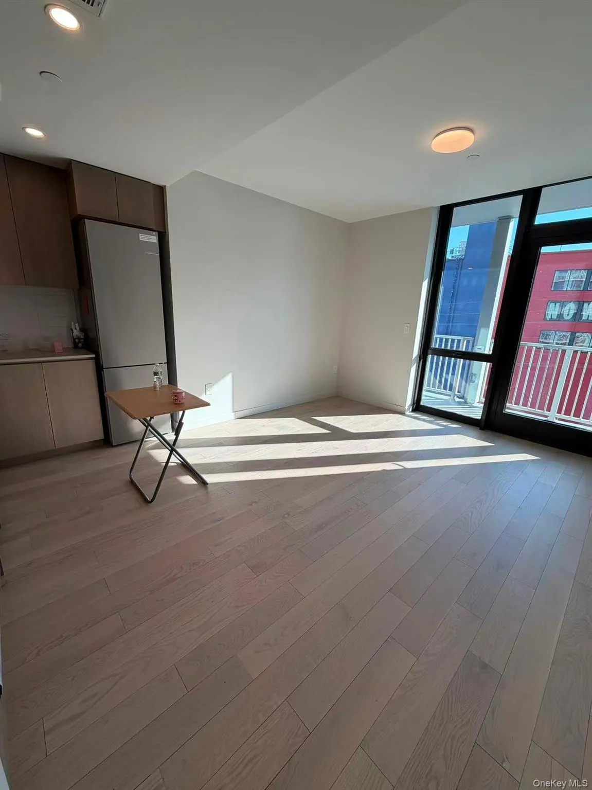 Empty room featuring a wall of windows, light wood-style floors, and recessed lighting Empty room featuring a wall of windows, light wood-style floors, and recessed lighting