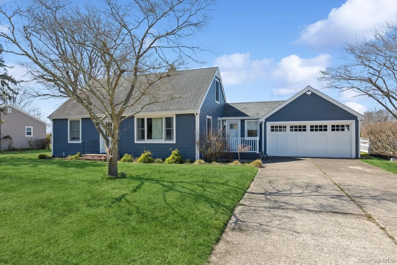 View of front facade with concrete driveway, a front yard, roof with shingles, and an attached garage View of front facade with concrete driveway, a front yard, roof with shingles, and an attached garage