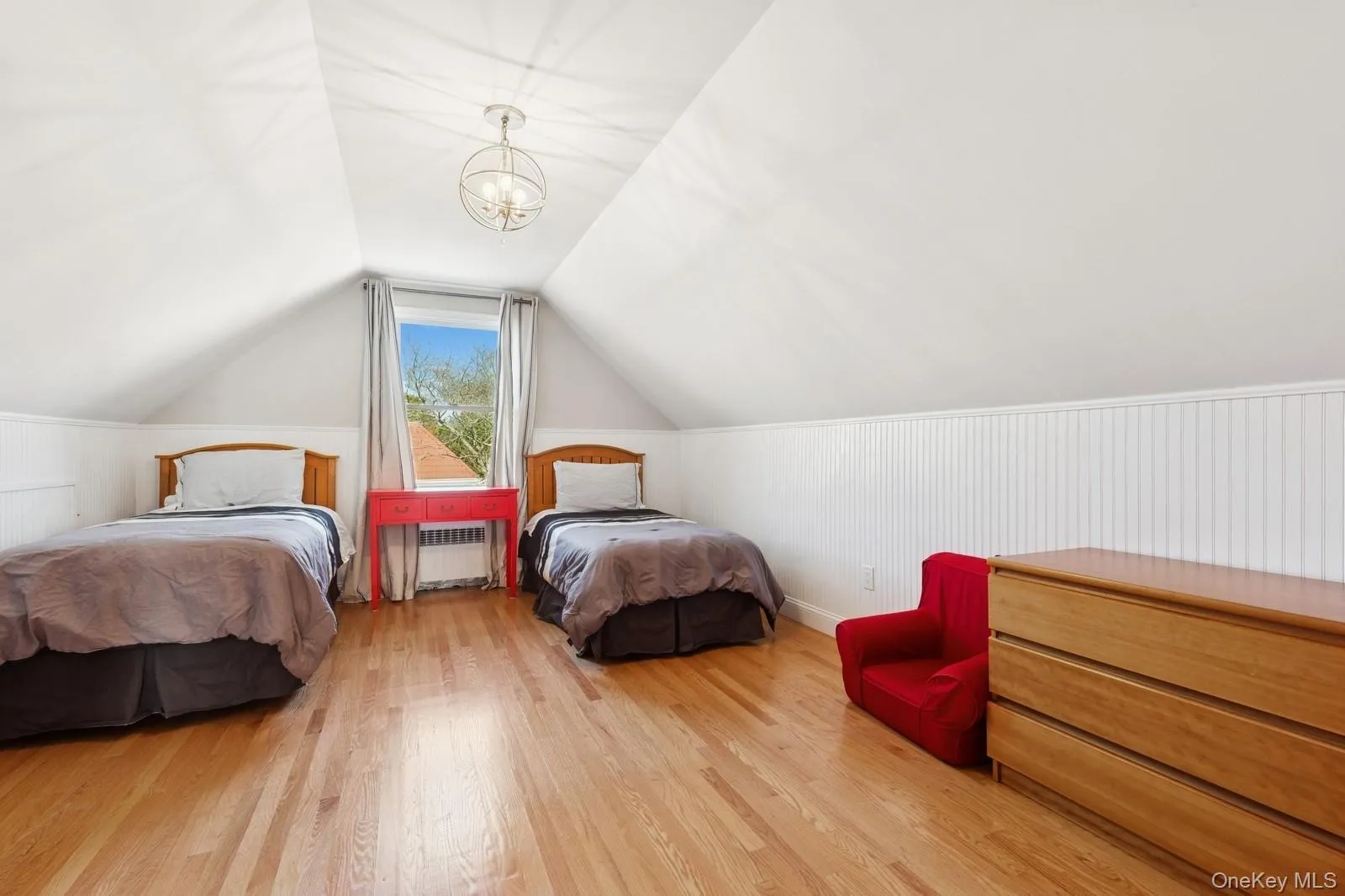 Bedroom with lofted ceiling, a chandelier, light wood-type flooring, and radiator heating unit Bedroom with lofted ceiling, a chandelier, light wood-type flooring, and radiator heating unit