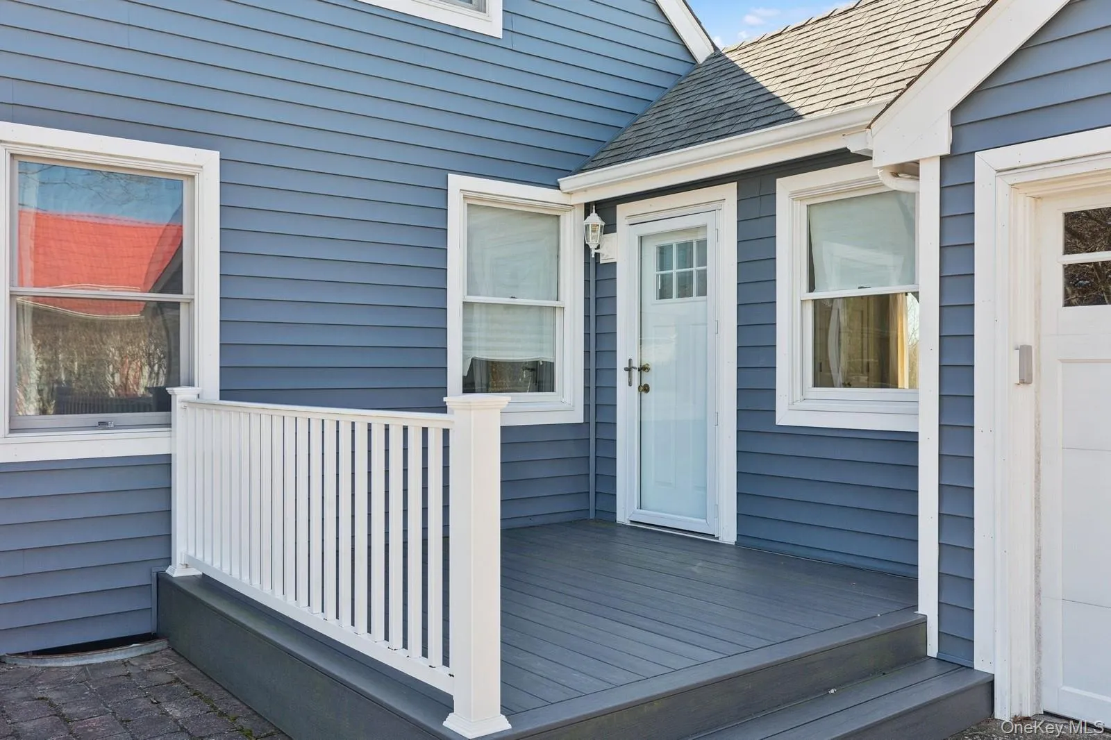 Doorway to property featuring roof with shingles and a deck Doorway to property featuring roof with shingles and a deck