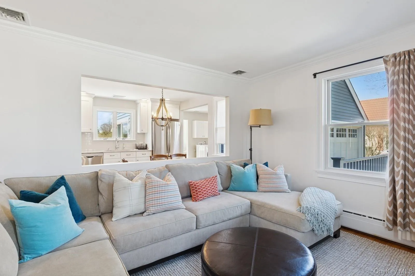 Living area with a chandelier, crown molding, a baseboard heating unit, and wood finished floors Living area with a chandelier, crown molding, a baseboard heating unit, and wood finished floors