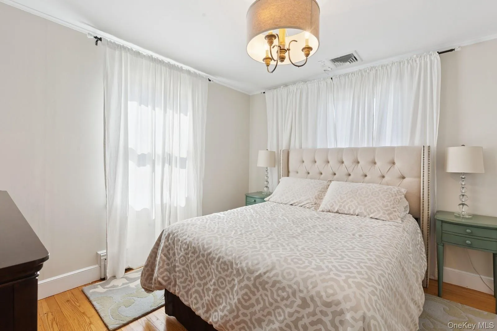 Bedroom featuring light wood-style flooring and a chandelier Bedroom featuring light wood-style flooring and a chandelier