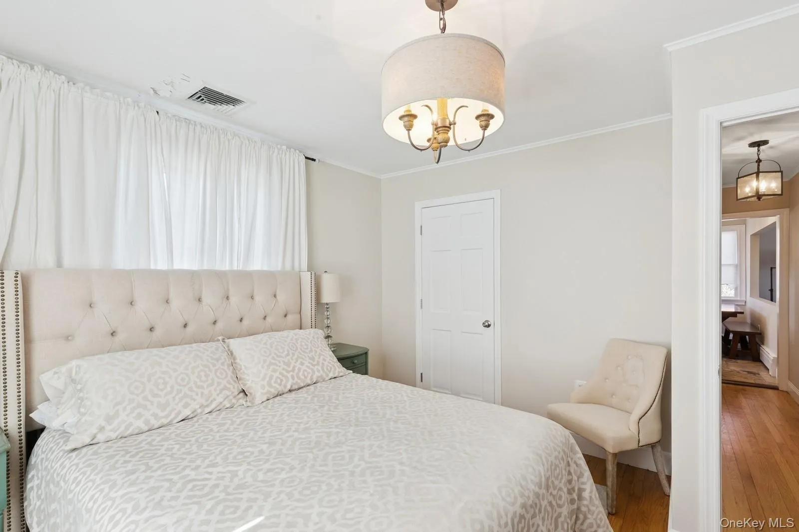 Bedroom featuring a chandelier, wood finished floors, and ornamental molding Bedroom featuring a chandelier, wood finished floors, and ornamental molding