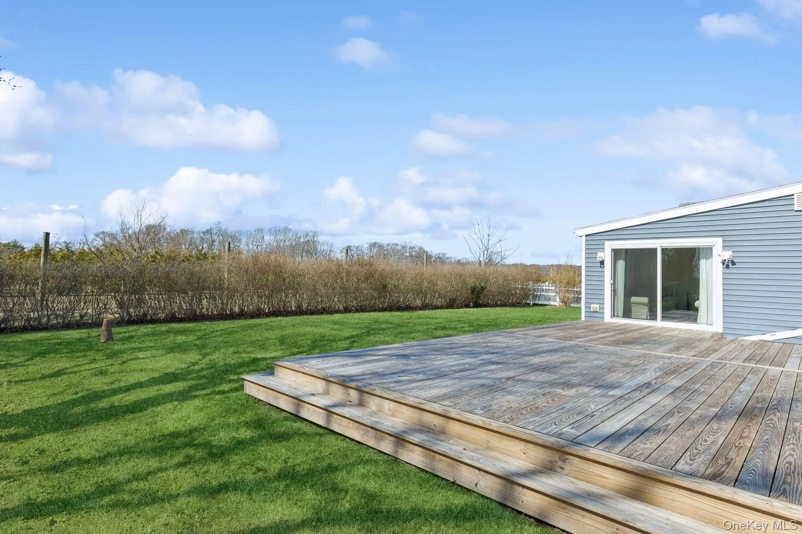Wooden terrace featuring a lawn Wooden terrace featuring a lawn