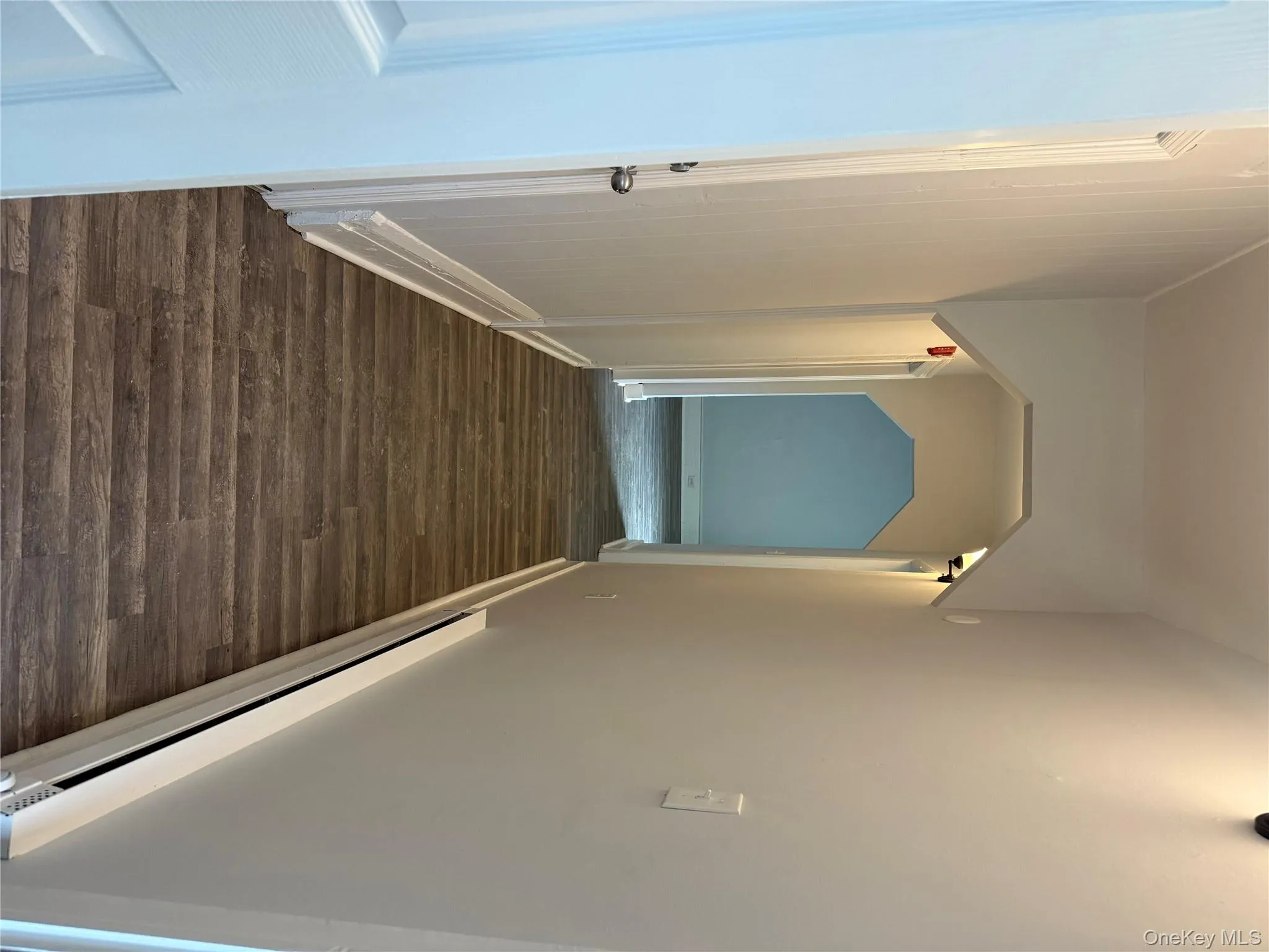 Hallway with a baseboard heating unit, dark wood-type flooring, and arched walkways Hallway with a baseboard heating unit, dark wood-type flooring, and arched walkways