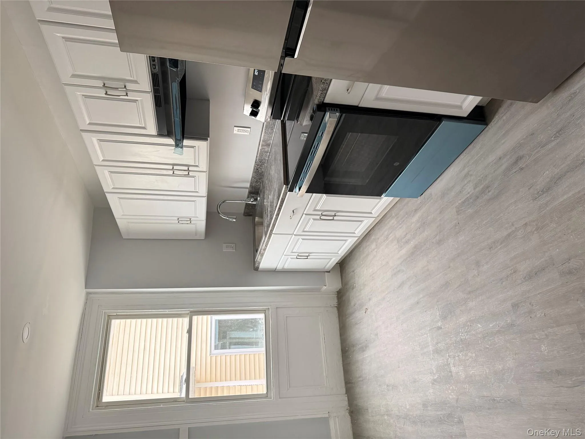 Kitchen featuring stove, refrigerator, white cabinets, light wood-style floors, and ventilation hood Kitchen featuring stove, refrigerator, white cabinets, light wood-style floors, and ventilation hood