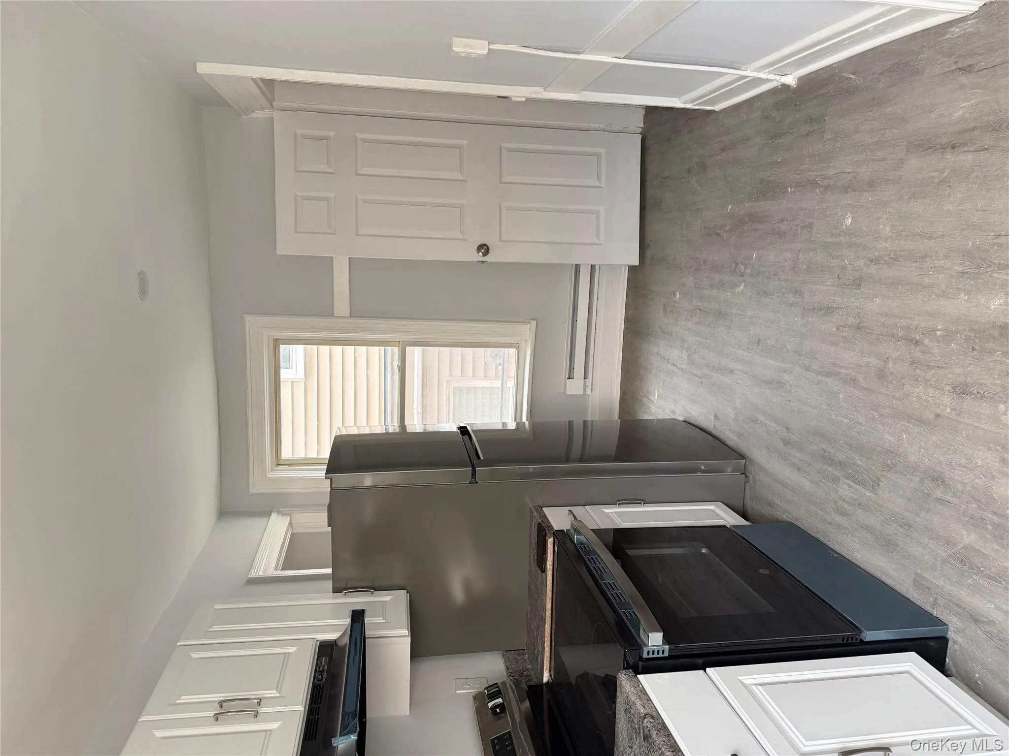 Kitchen featuring range, white cabinetry, range hood, and light wood-style floors Kitchen featuring range, white cabinetry, range hood, and light wood-style floors