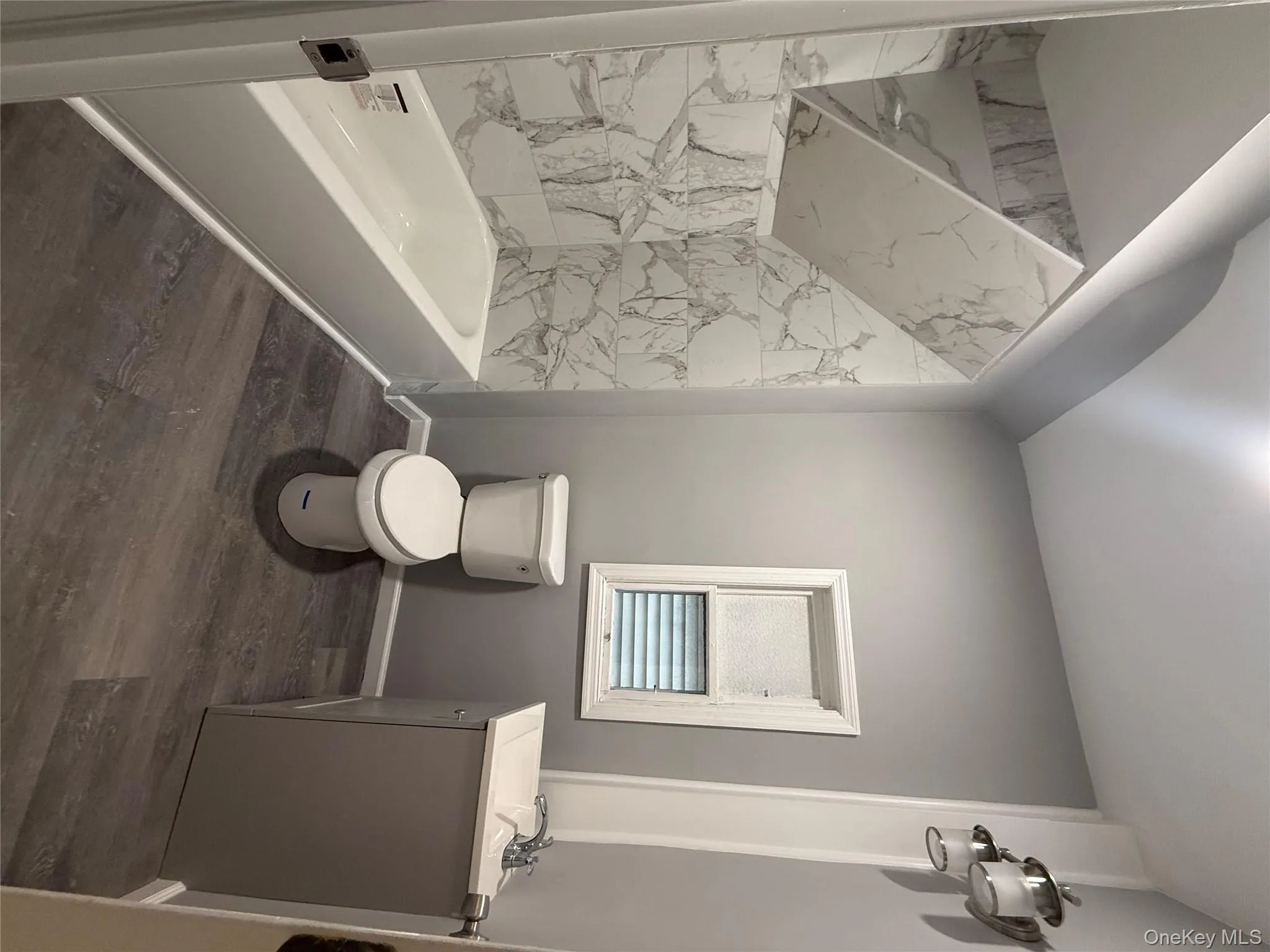 Full bathroom with vanity, dark wood-type flooring, and tub / shower combination Full bathroom with vanity, dark wood-type flooring, and tub / shower combination