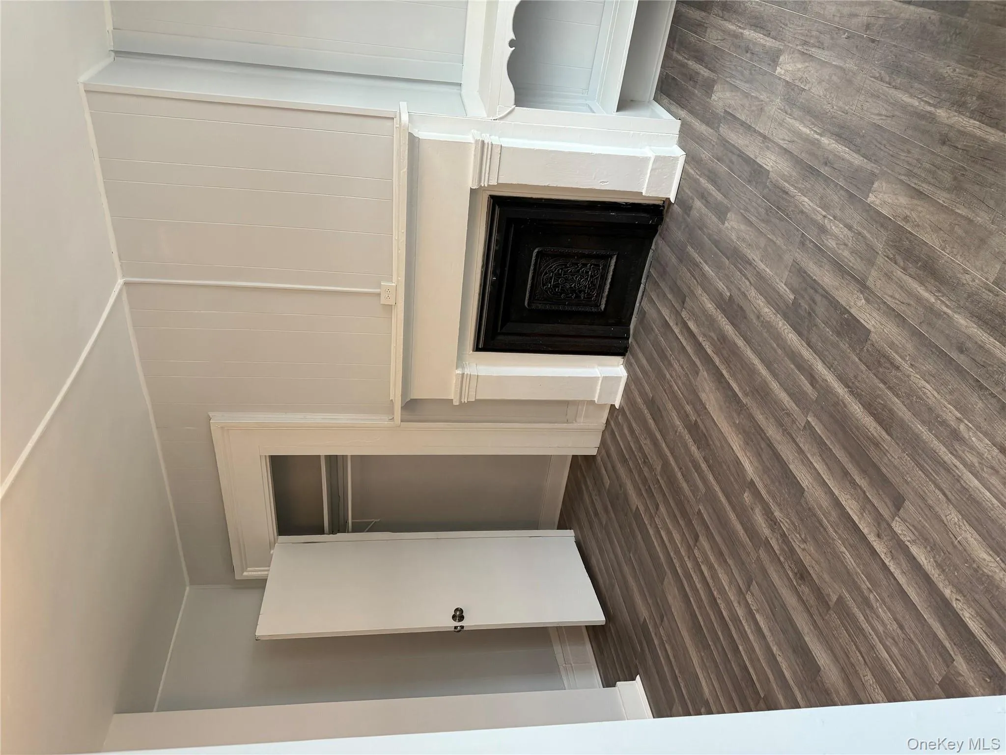 Unfurnished living room featuring dark wood finished floors and a fireplace Unfurnished living room featuring dark wood finished floors and a fireplace