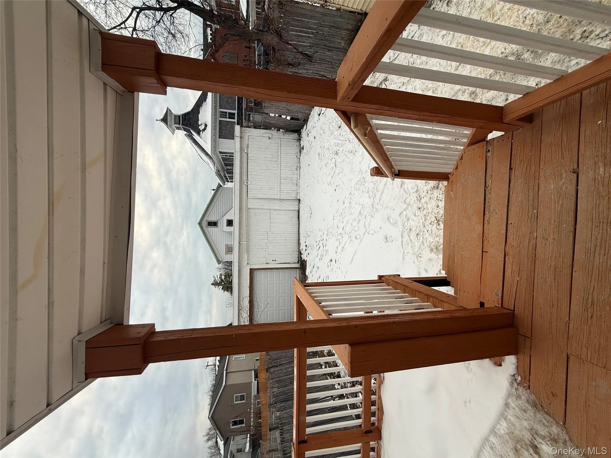 Snow covered deck with a fenced backyard and an outbuilding Snow covered deck with a fenced backyard and an outbuilding