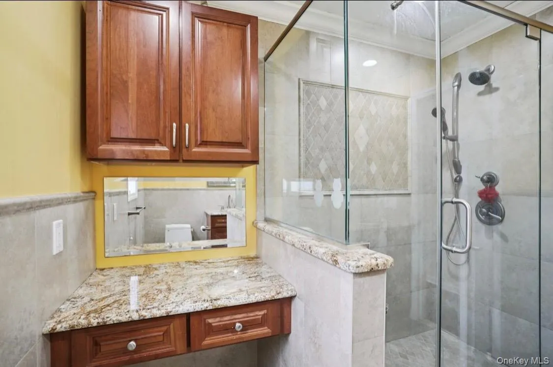 Bathroom with a shower stall, ornamental molding, and vanity Bathroom with a shower stall, ornamental molding, and vanity