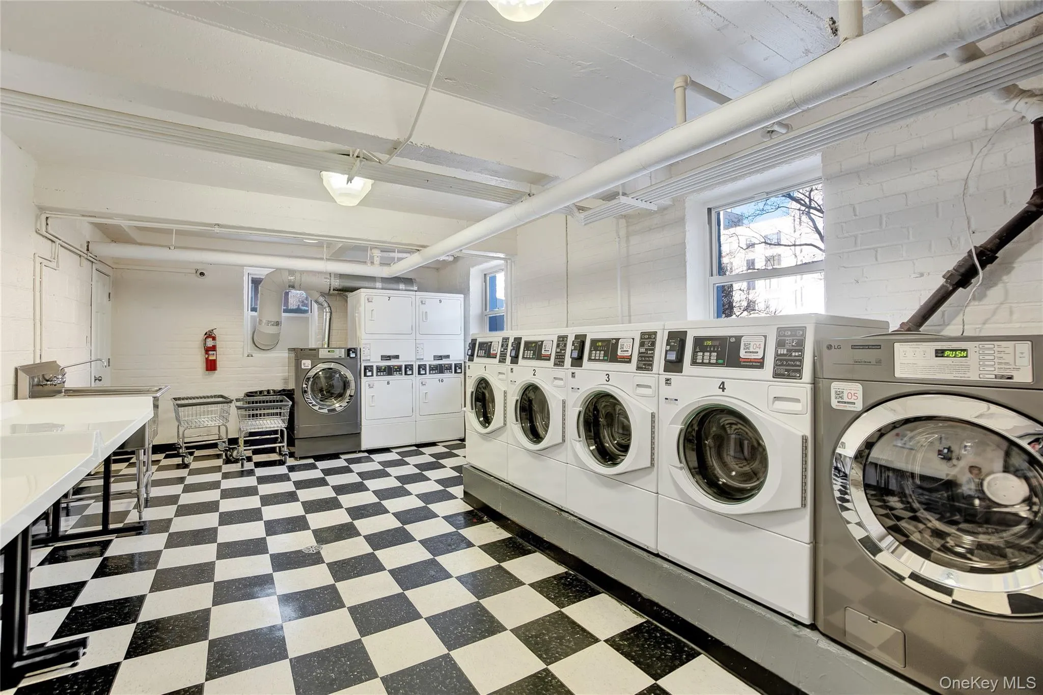 Shared laundry room with washing machine and clothes dryer and stacked washer and clothes dryer Shared laundry room with washing machine and clothes dryer and stacked washer and clothes dryer