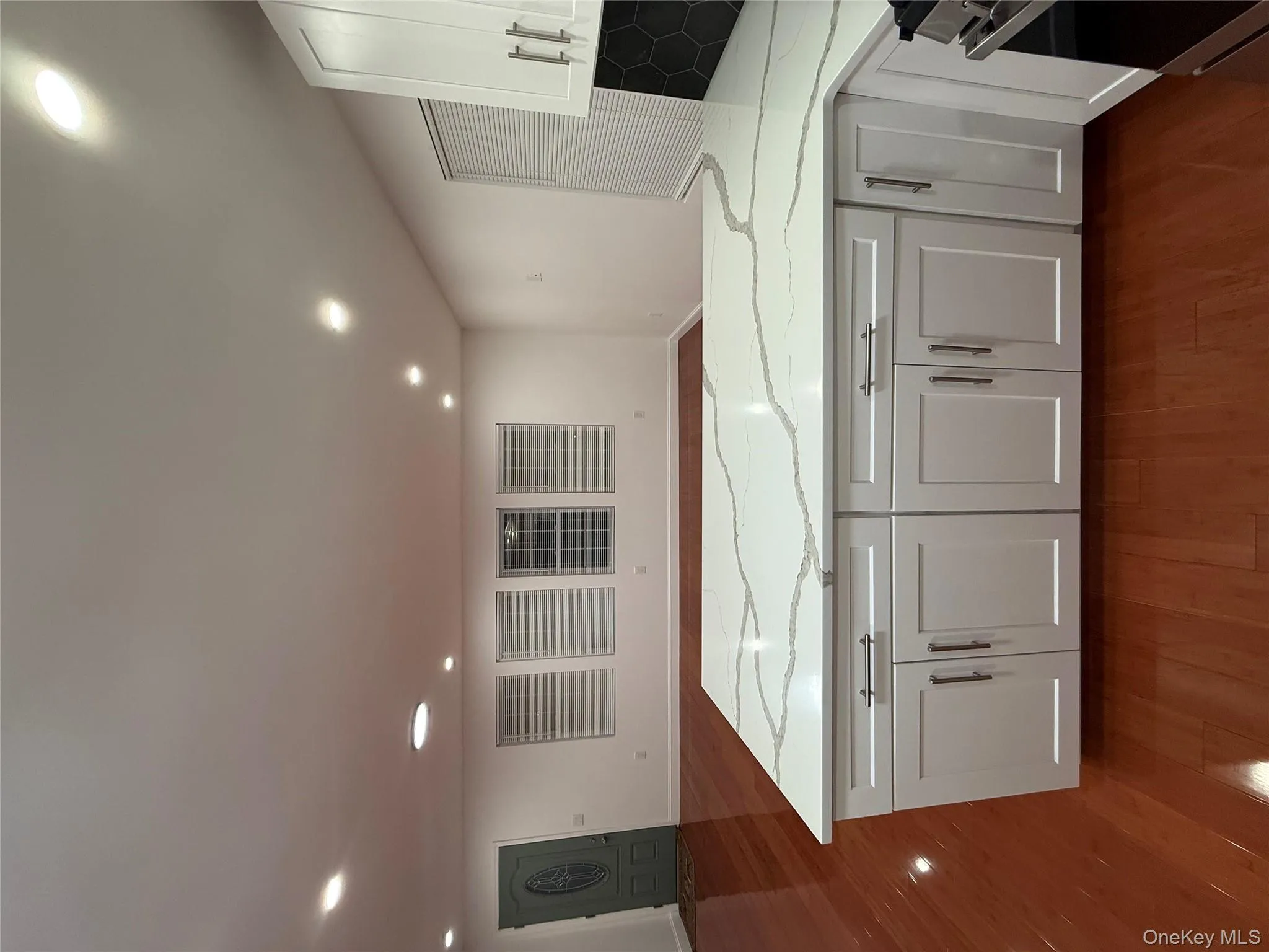 Kitchen with white cabinetry, light stone counters, a peninsula, recessed lighting, and open floor plan Kitchen with white cabinetry, light stone counters, a peninsula, recessed lighting, and open floor plan