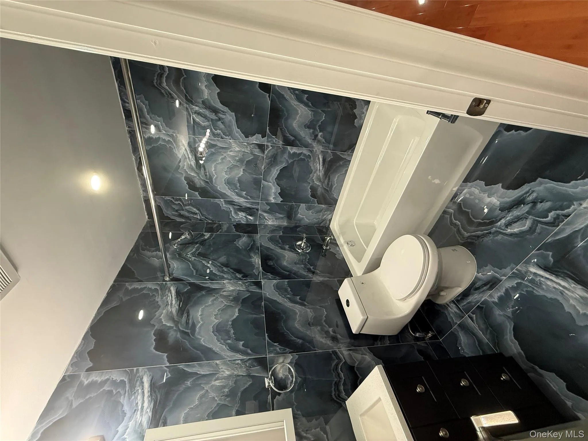 Bathroom with tile walls, marble tiled flooring, vanity, and shower / bathtub combination Bathroom with tile walls, marble tiled flooring, vanity, and shower / bathtub combination